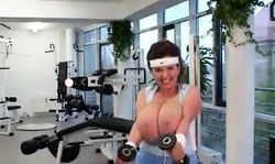 Sporty MILF is doing exercises in the gym while being topless