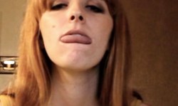 Gorgeous redhead chick smiles in cam and shows off her tongue