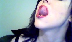 Dark-haired babe with pierced lip is playing with her tongue