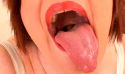 Redhead MILF with big boobs demonstrates her long tongue