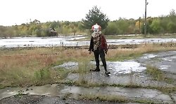 A horror clown mocks schoolgirl in an abandoned building