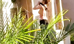 Gorgeous blonde is taking off her black dress outdoors