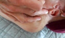 parting her panties to show hairy pussy and hard clit