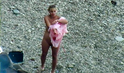 Slender tanned chick is getting spotted topless on the beach