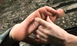 Smiling sweetie is smelling and touching her gf's soles