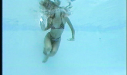 Slender babe in tight bikinis is swimming in a hot way