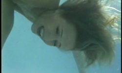 Smiling brunette with cute face demonstrates her tits underwater