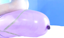 Smiling redhead lady rides a giant purple balloon in a hot way