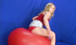 Sweet blonde in white panties jumps on a big red balloon