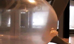 Busty brunette in yellow bodystocking plays with her balloon