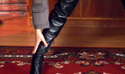 Smiling hottie in leather boots shows off her gorgeous boobs