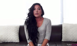 Black-haired young chick laughing and undressing at backroom casting