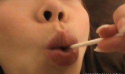 Brunette from Japan is sucking a lollipop in a hot way